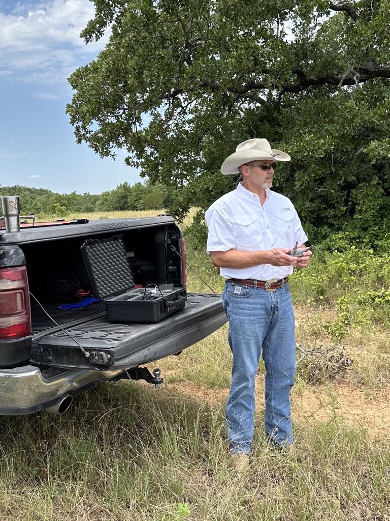 Sean Kirkpatrick at his truck tailgate with drone equipment on North Texas ranch land